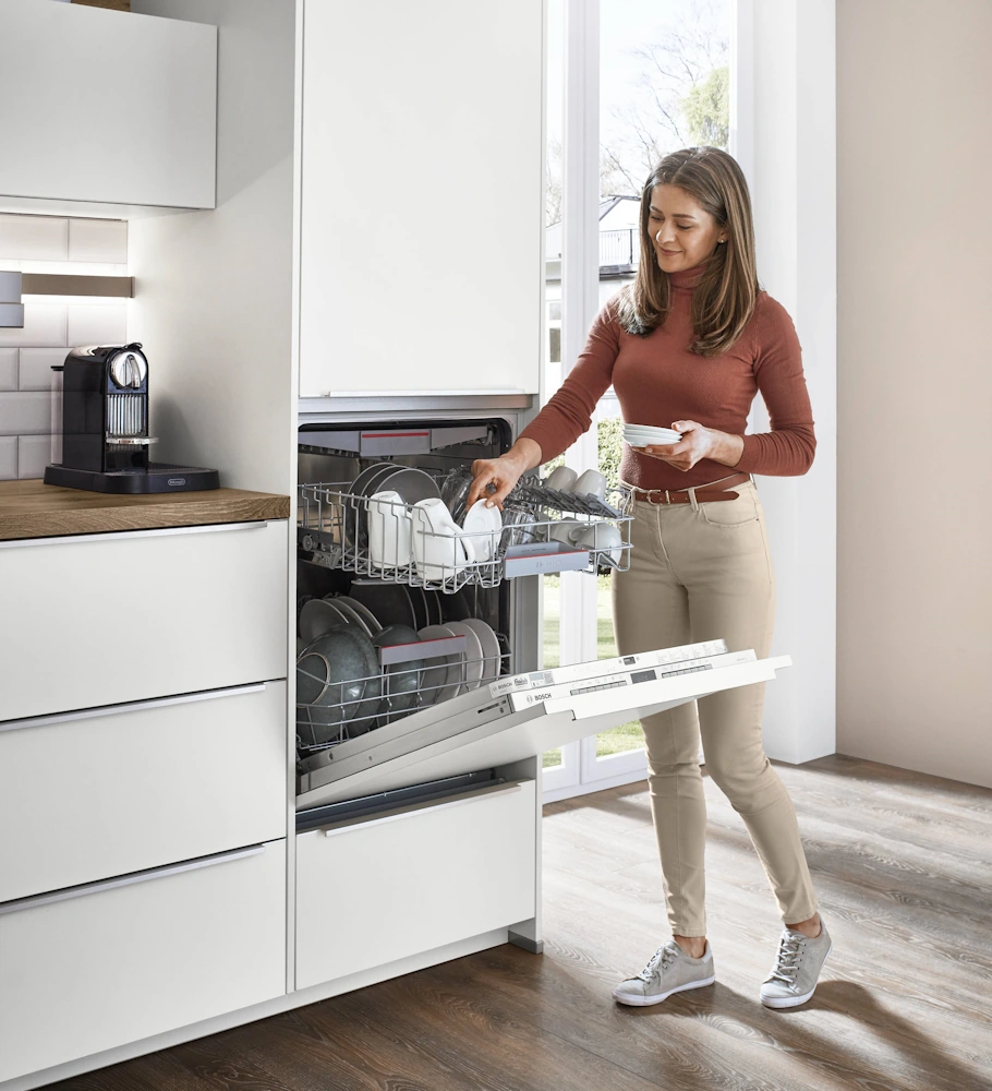 Person emptying the built-in dishwasher Person emptying the built-in dishwasher
