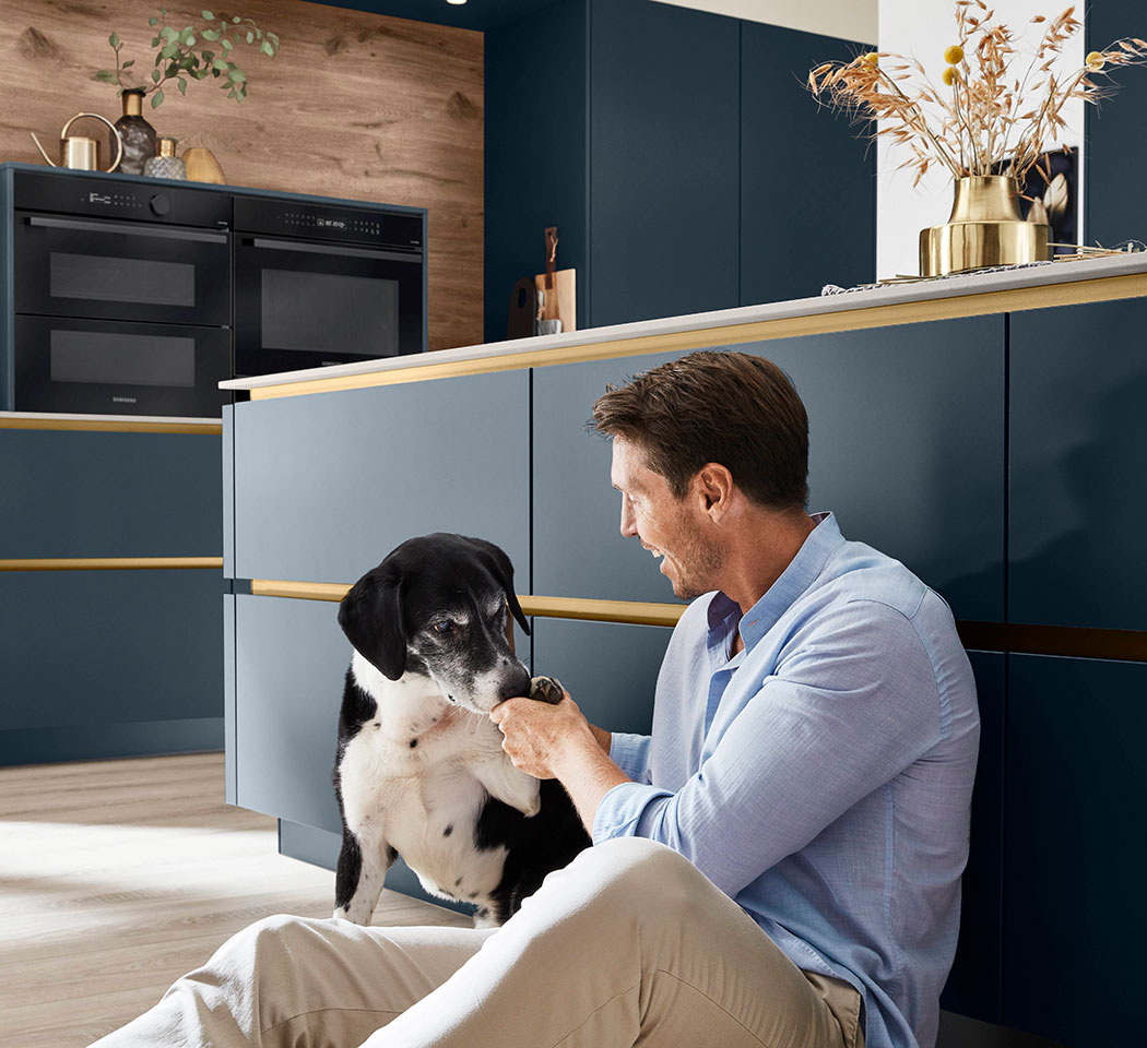 Man and dog in a blue kitchen Man and dog in a blue kitchen