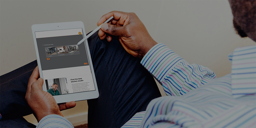 Man is using a kitchen planning tool on a tablet device Man is using a kitchen planning tool on a tablet device